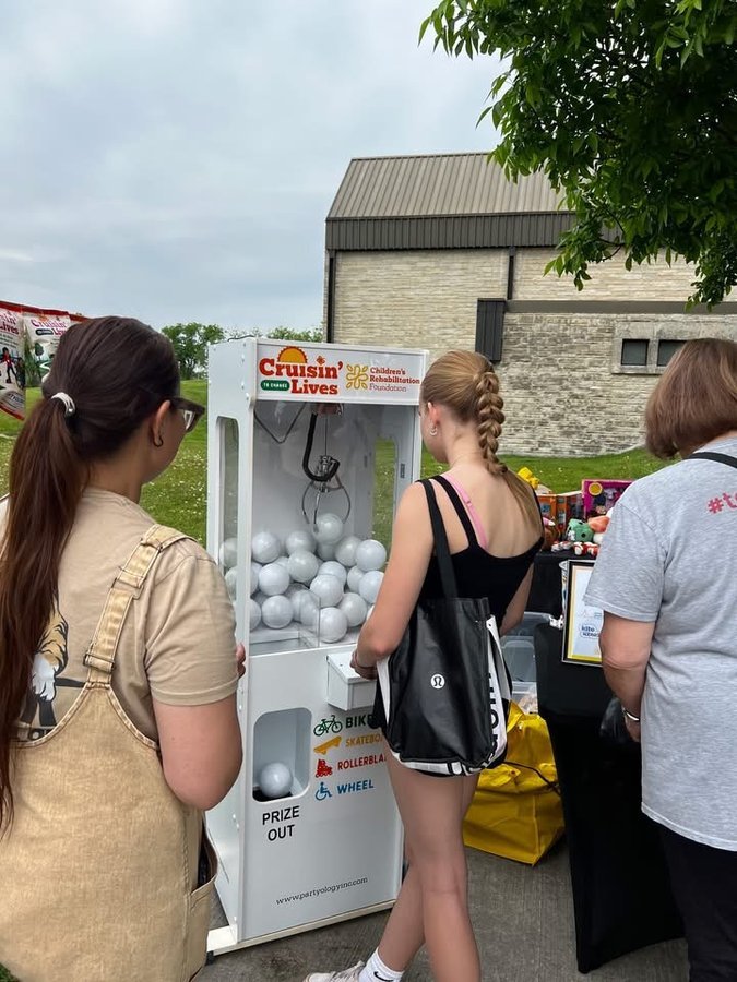 Crowd at Partyology branded claw machine Winnipeg